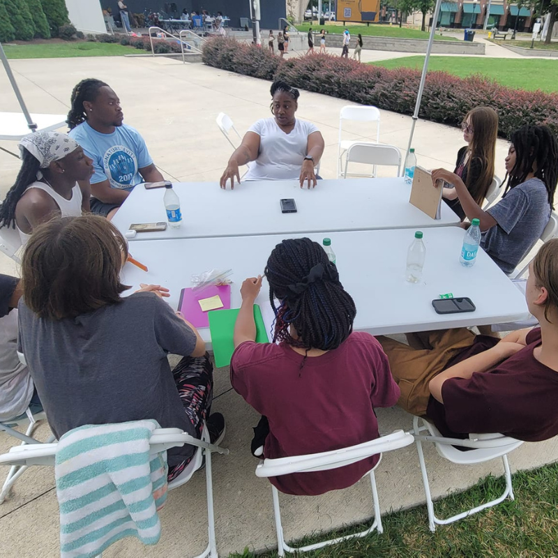 group of students learning about the arts around a table